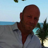 Otto Knudsen sidder på en strand i et varmt land